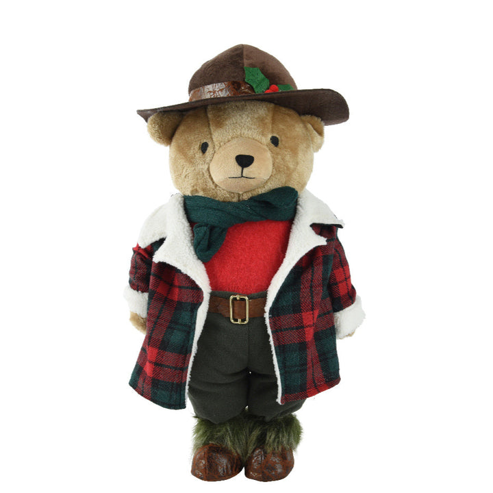 Teddy bear dressed in a plaid outfit with a hat on a white background