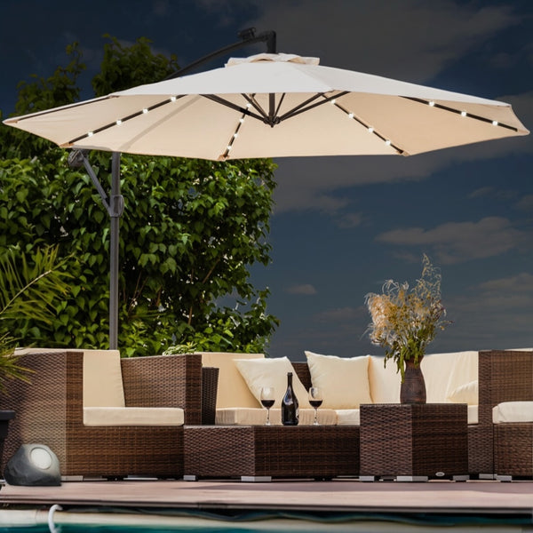 Outdoor patio set with beige umbrella, cushions, and a vase on a wooden deck.