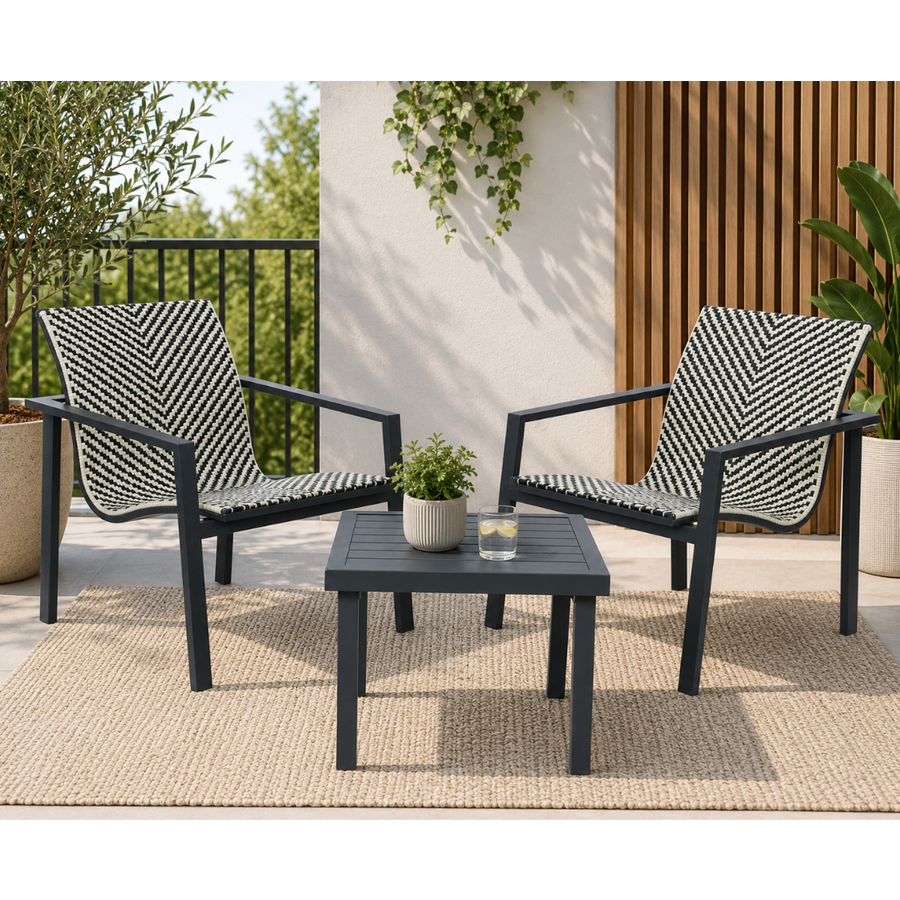 A 3-piece outdoor patio furniture set featuring two armchairs with black and white chevron woven rope seats and backs, and a matching square coffee table, arranged on a beige woven rug on a patio.