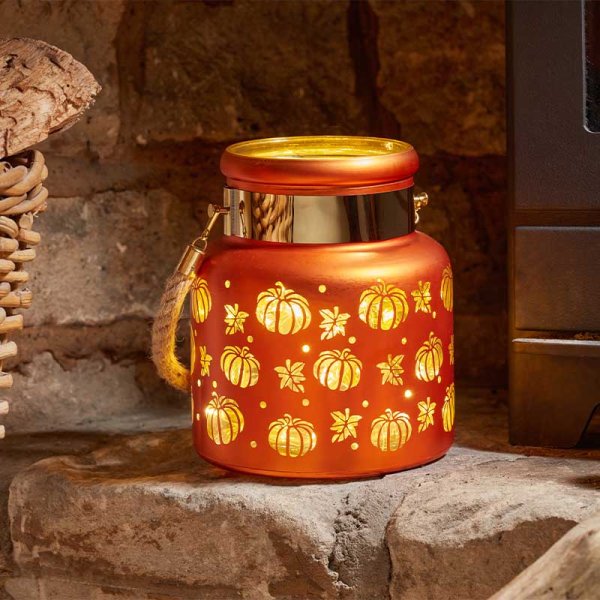 Decorative lantern with pumpkin pattern on a stone surface
